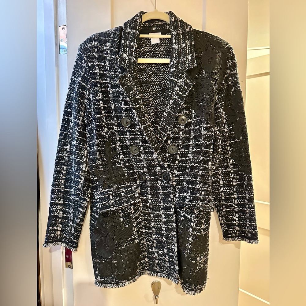 Contemporary black & white blazer, a modern fringed hem, and applique accents.